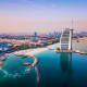 Aerial view of Burj Al Arab and Jumeirah Beach Hotel with Dubai skyline and turquoise waters